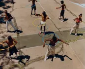Kids outside playing with a hula hoop.